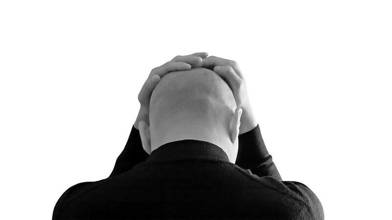 Schwarz-weiß Bild Rückenansicht Mann hält sich die Hände auf Kopf, Glatze