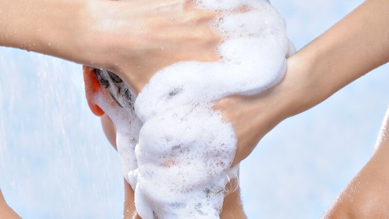 Rückansicht Frau wäscht sich lange Haare unter der Dusche