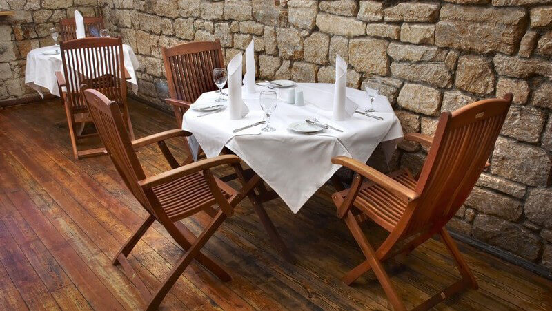 Gedeckter Tisch mit Holzstühlen im Restaurant