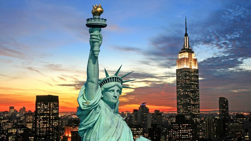 Freiheitsstatue New York, im Hintergrund Sykline am Abend