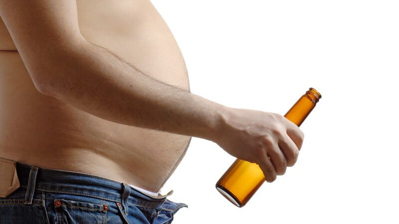 Nahaufnahme Mann mit Bierbauch und offener Hose mit leerer Bierflasche in Hand
