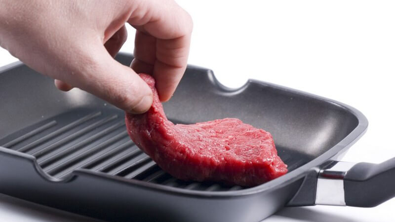 Steak wird in Pfanne gelegt