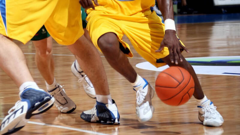 Zwei Basketballer in gelben Trikots in Aktion