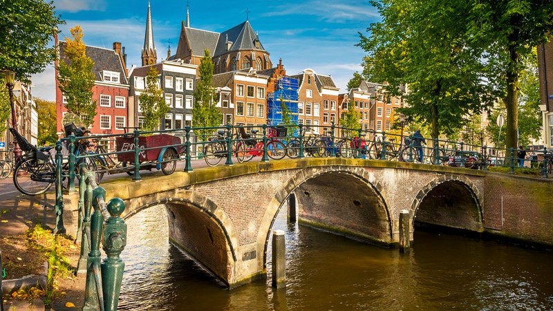 Typisches Stadtbild von Amsterdam, Niederlande: Brücke mit vielen Fahrrädern