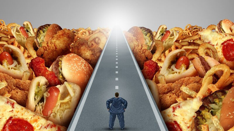 Dicker Mann steht auf einer Straße zwischen lauter Fast Food und sieht Licht am Ende der Straße (Fotomontage)