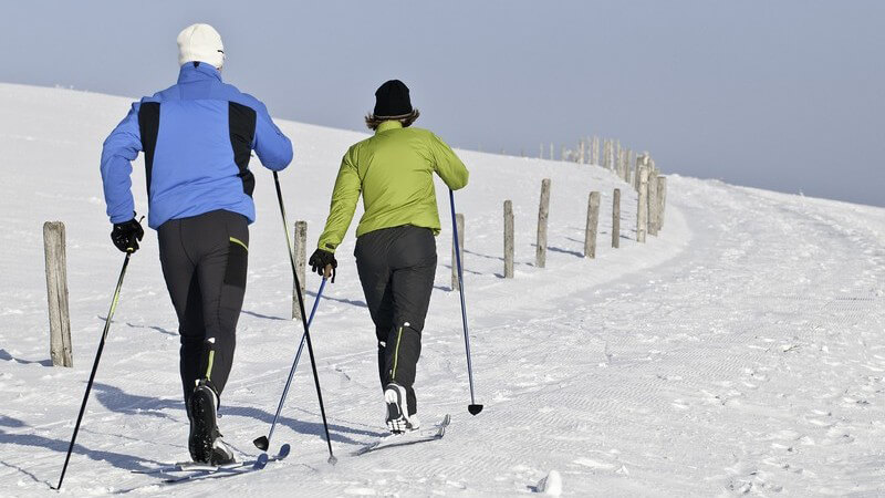 Paar beim Skilanglauf auf einsamem Weg
