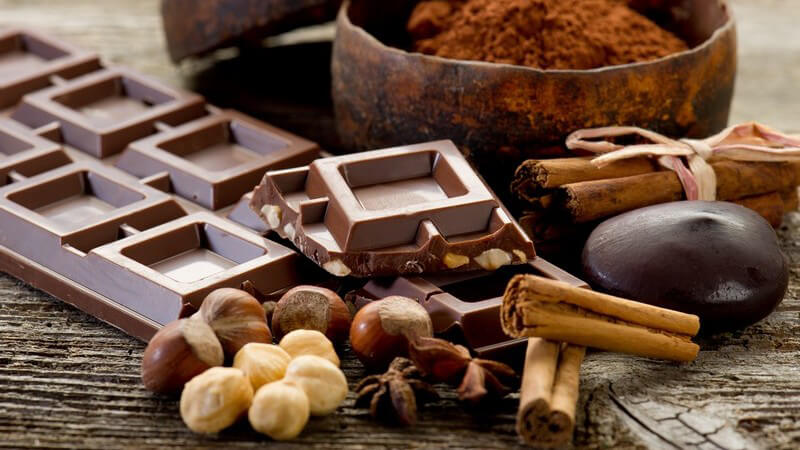 Schokolade neben Nüssen und Zimtstangen
