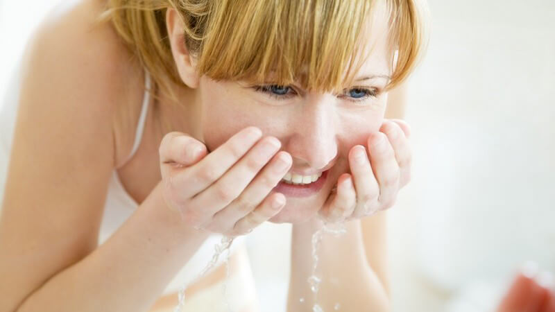 Junge Frau beim Gesichtwaschen