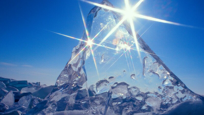 Eiswürfel in Form von Berg mit strahlendem Sonnenschein unter blauem Himmel