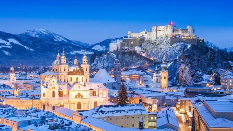 Stadtbild von Salzburg im Schnee, Winter, im Hintergrund Berge