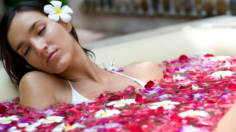 Frau entspannt im Blütenbad