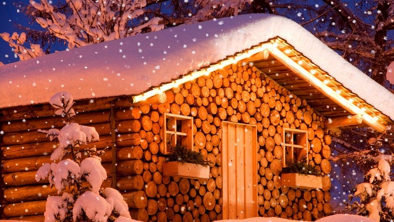 Beleuchtete Holzhütte im tiefen Schnee, Weihnachtszeit