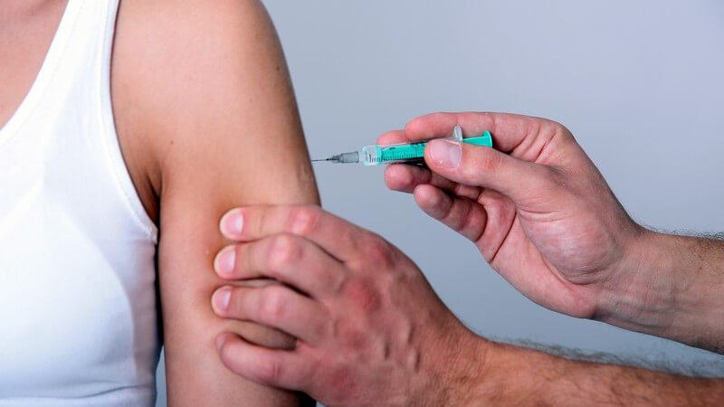 Impfung: Frau bekommt Spritze in Oberarm