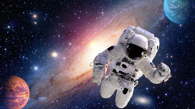Astronaut schwebt im Weltall, die Milchstraße und zwei Planeten im Hintergrund