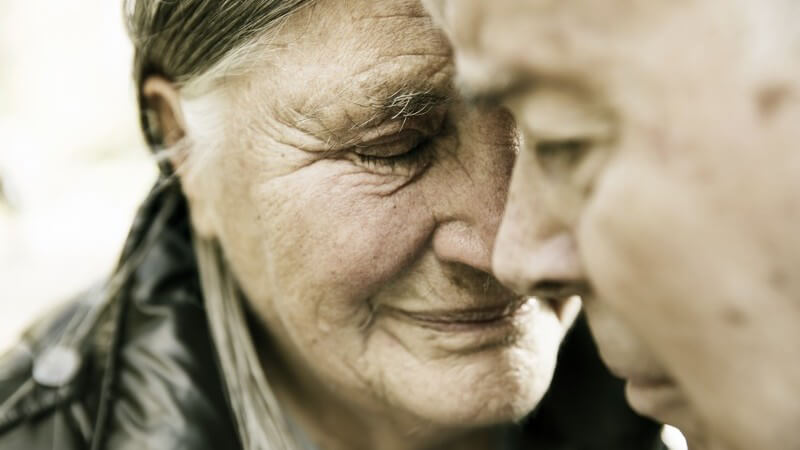 Altes Ehepaar Kopf an Kopf, wirken traurig, Foto in Grautönen