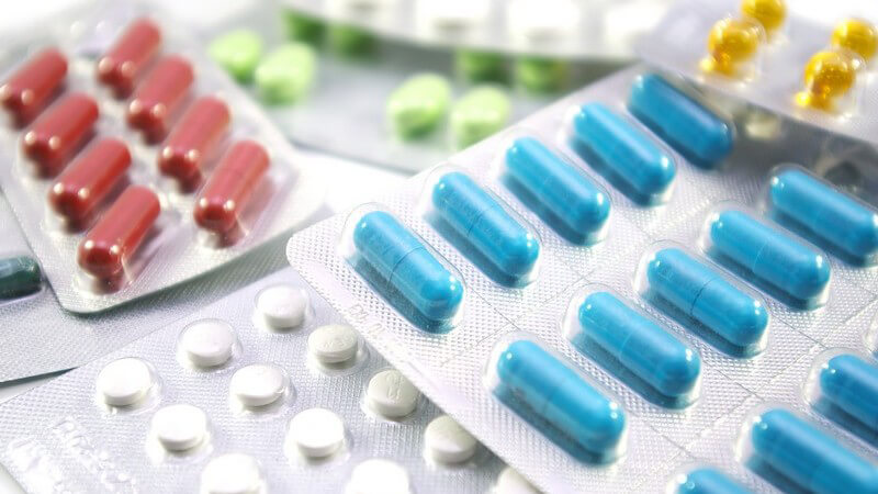 Arzneimittel - Pillenpackungen mit blauen, roten, gelben, grünen und weißen Pillen