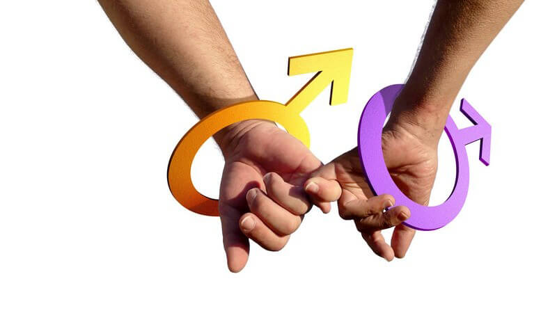 Die Hände zweier schwuler Männer mit dem Marszeichen am Handgelenk