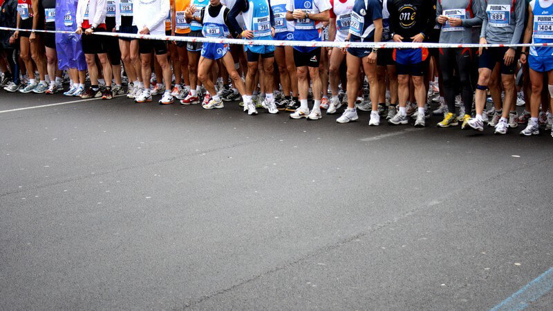 Viele Sportler stehen hinter einer Abgrenzung vor dem Marathon Start