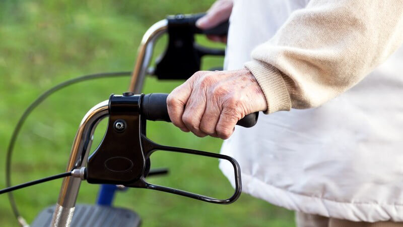Gebehinderte Seniorin mit einer Gehhilfe (Rollator)