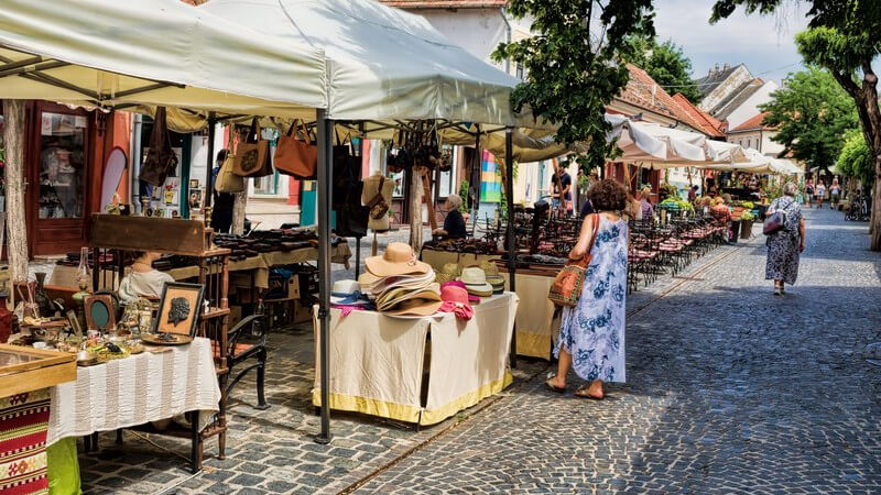 Trödelmarktstände entlang einer alten gepflasterten Straße in Szentendre, Ungarn