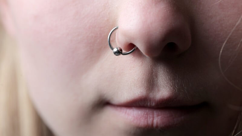 Frau mit einem Piercingring am Nasenflügel (Nostril-Piercing)