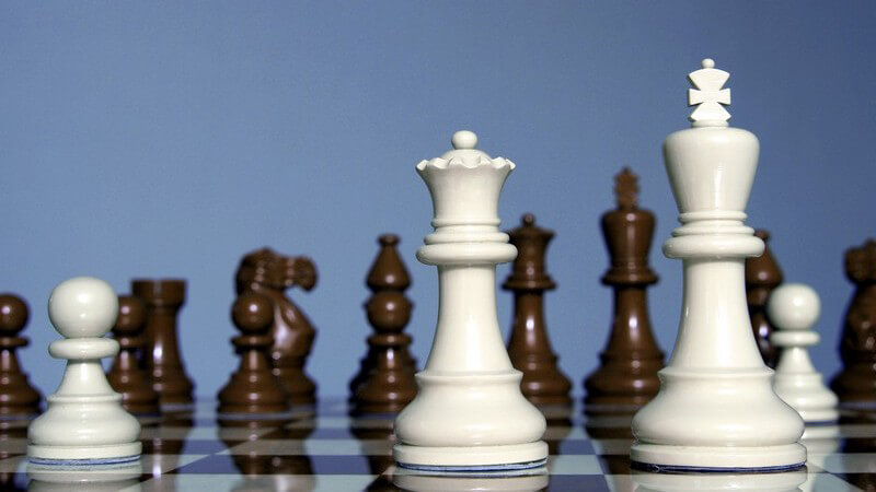 Schwarze und weiße Schachfiguren auf Schachbrett