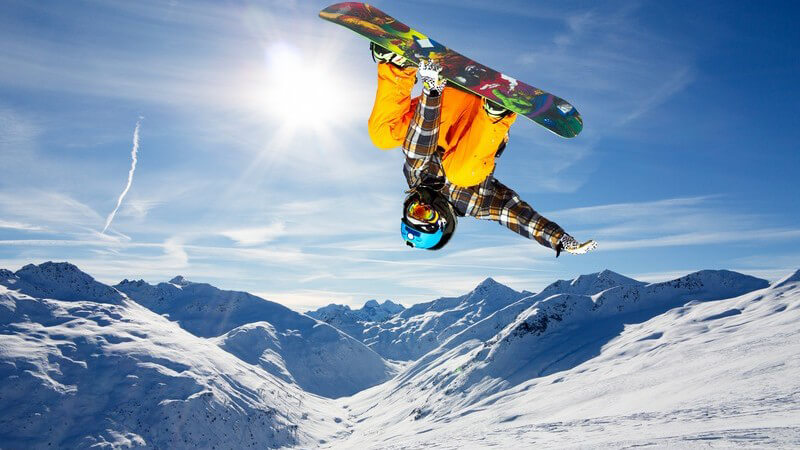 Snowboarder auf der Piste macht gerade einen Flip
