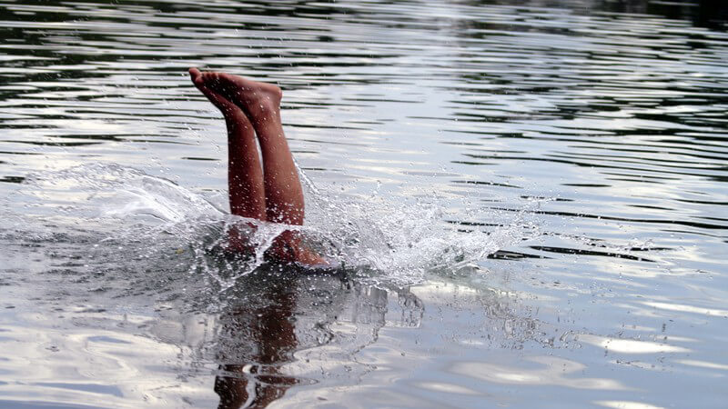Sprung und Eintauchen ins Wasser eines Sees