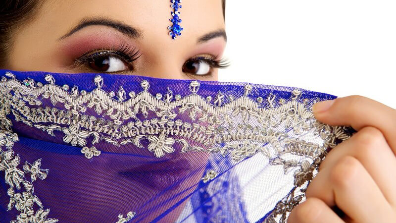 Gesichtsportrait einer indischen Frau, halb hinter Tuch versteckt