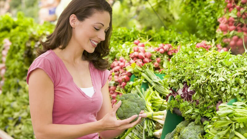Junge Frau im Supermarkt in Gemüseabteilung