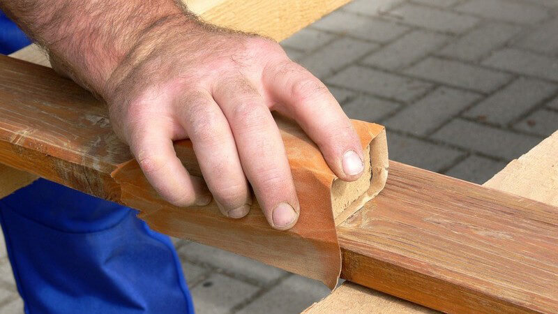 Handwerker oder Schreiner beim Abschmirgeln von Holz