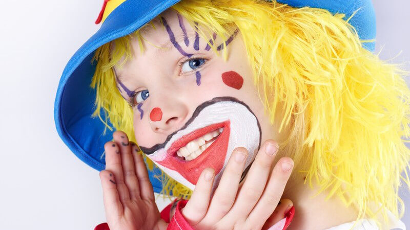 Als lustiger Clown verkleidetes Mädchen, gel-blauer Hut und gelbe Perücke