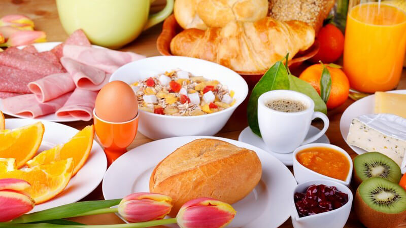 Reich gedeckter Frühstückstisch mit Tulpen und allem, was zu einem Frühstück gehört