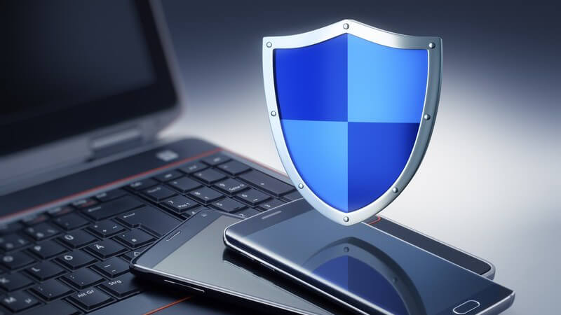 Blaues Wappenschild schwebt über einem schwarzen Laptop und zwei Smartphones