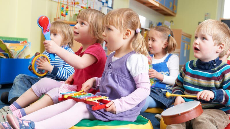 Kleine Kindergartenkinder beim Musizieren in der Gruppe