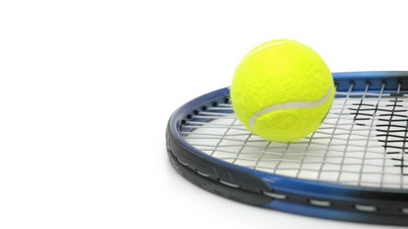 Tennisball auf Tennisschläger auf weißem Hintergrund