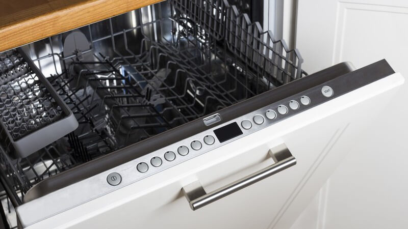 Geöffnete, leere Geschirrspülmaschine mit weißer Küchenfront
