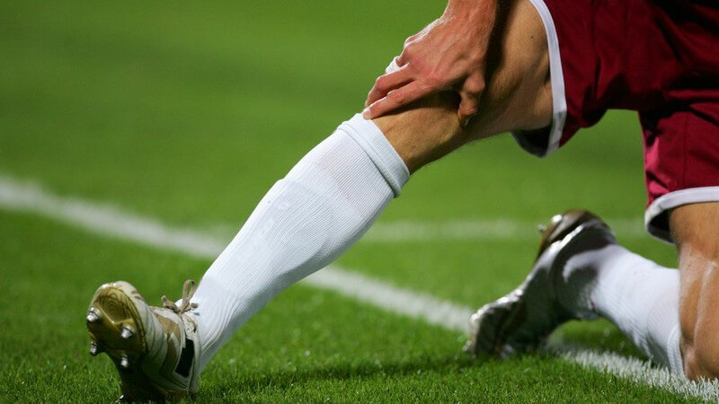 Nahaufnahme Beine eines Fußballers auf Fußballfeld