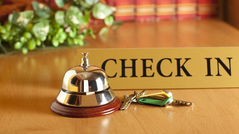 Hotelempfang, Rezeption mit Zimmerschlüssel, "Check in"-Schild und Klingel