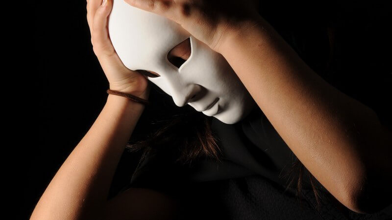 Junge Frau in schwarz mit weißer Gesichtsmaske, Theater