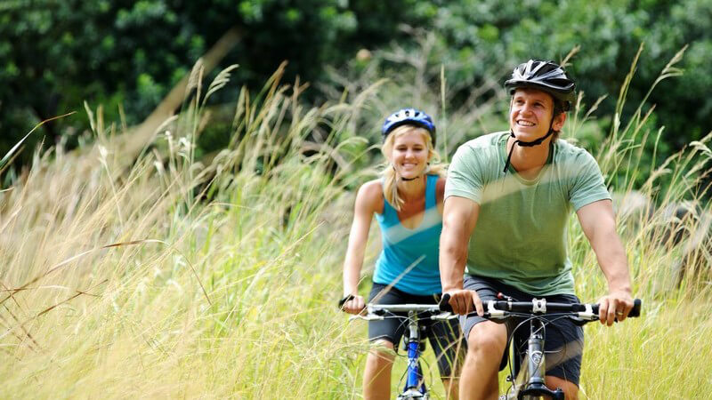 Junges Paar mit Fahrradhelm beim Mountainbiking