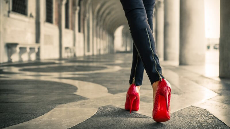 Frau spaziert in Lederhose und roten High Heels durch Venedig