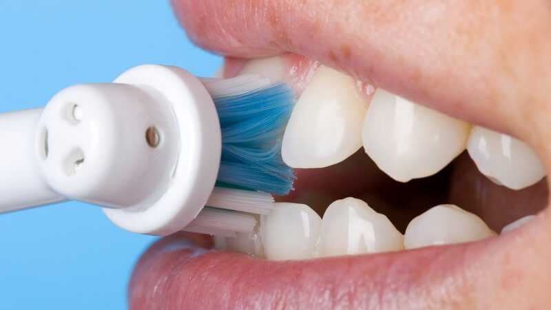 Zähne - Putzen der Schneidezähne mit elektrischer Zahnbürste