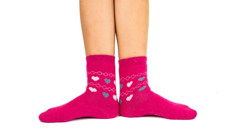 Beine in pinken Socken mit kleinen Herzchen