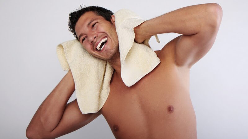 Junger nackter mann trocknet sich das Haar mit gelbem Handtuch