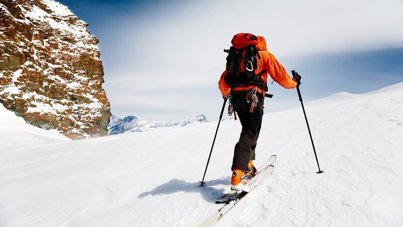 Skilangläufer klettert Berg hoch