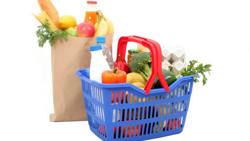 Tüte und Einkaufskorb mit vielen gesunden Lebensmitteln wie Obst und Gemüse