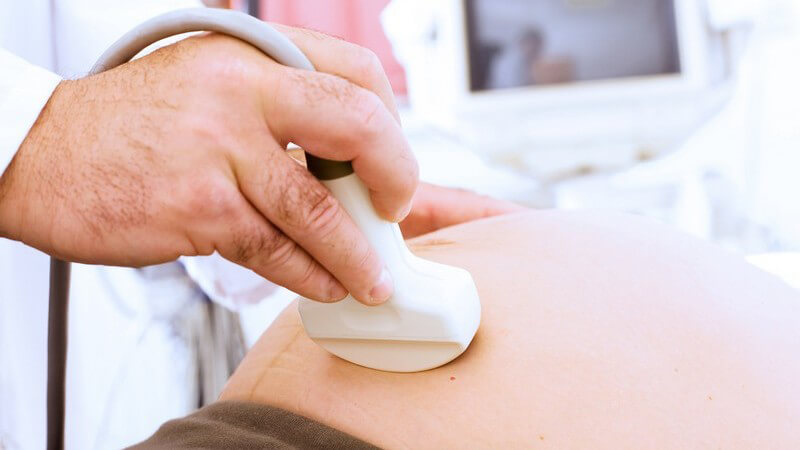 Nahaufnahme Ultraschallgerät auf schwangerem Bauch