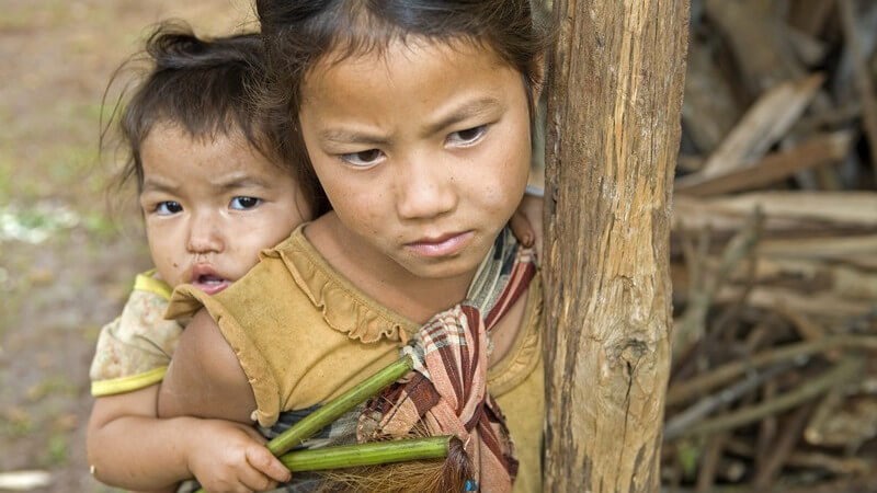 Zwei traurige kleine Hmong Geschwister, leben in Armut