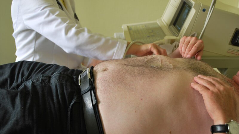 Übergewichtiger Mann bei Ultraschalluntersuchung in Praxis